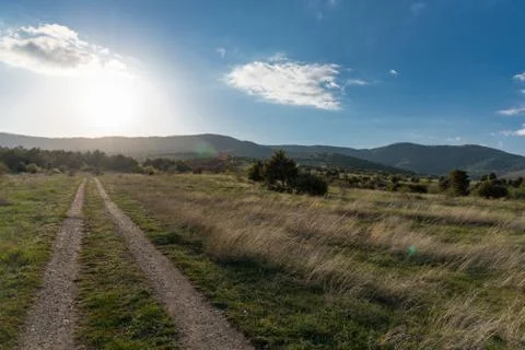 Mountain forest landscape under evening sky with clouds in sunlight road in.. Fotos de archivo