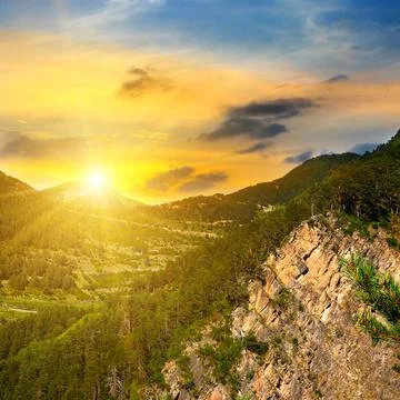 Mountain forest landscape under evening sky with clouds in sunlight. Fotos de archivo