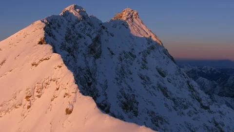 A Mountain gets hit with the first rays of sun in a winter morning Stock Footage 102217843