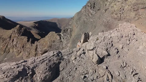 Mountain goats leaping along barren alpine ridge line Stock Footage 335764801
