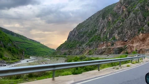 Mountain gorge road with rocky cliffs and sunset sky view Stock Footage 310247298
