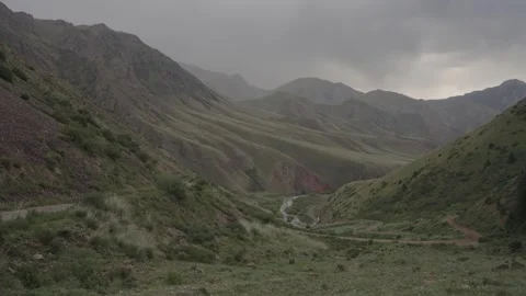 Mountain gorge with a winding river under storm clouds, Kyrgyzstan Stockbeeldmateriaal 347243028