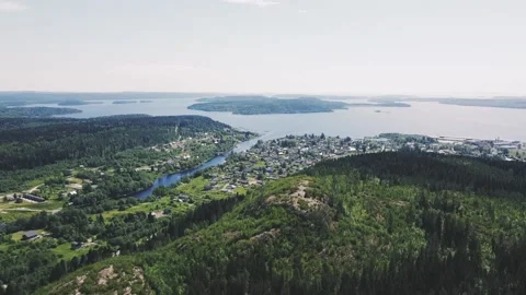 A mountain with green big trees, in the distance a small town with houses Vidéo 161824554