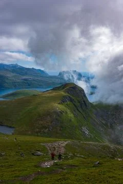 Mountain hikers exploring dramatic Lofoten landscape with fjord and clouds Foto stock
