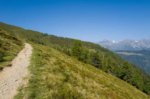 Mountain hiking path overlooking alpine valley Stock Photos
