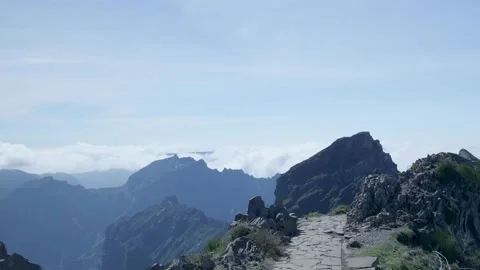Mountain hiking trail with clouds below the peaks Видео 333696078