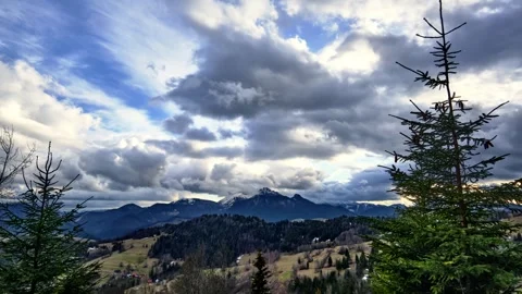 Mountain hilly landscape with trees and meadows, sun setting over the horizon, Stock Footage 243361613
