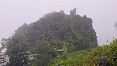 A mountain with a house on it and a bird flying in the sky Video stock 277632562
