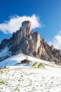 Mountain hut and Nuvolau peak after a summer snowfall. Passo Gia Stock Photos