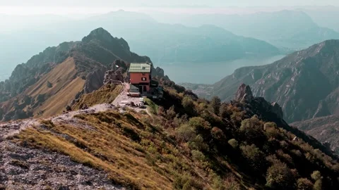 Mountain hut refuge on an alpine ridge with lake como in the background Stock Footage 346899884