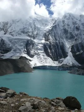 Mountain Ice wall falling to the Tilicho lake 스톡 사진