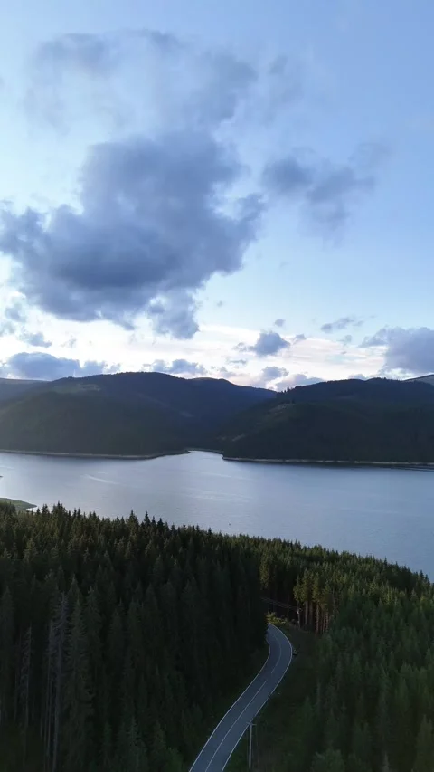 Mountain Lake and Forest Road Aerial View at Dusk in Romania Stock Footage 334321545