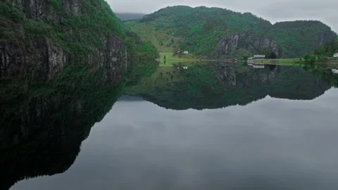 Mountain lake bordered by forest and Norwegian houses in rural Norway. Stock Footage 328132261