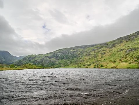 Mountain lake with dramatic cloudy sky 写真素材