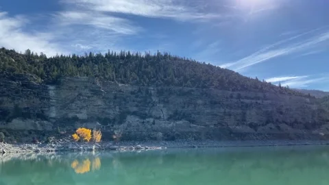 Mountain Lake with high cliffs and bright yellow tree 4K Stock-Footage 141888415