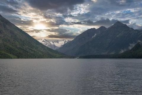 Mountain lake at Multinsky Lakes with dramatic clouds and snowy peaks, Altai Foto stock