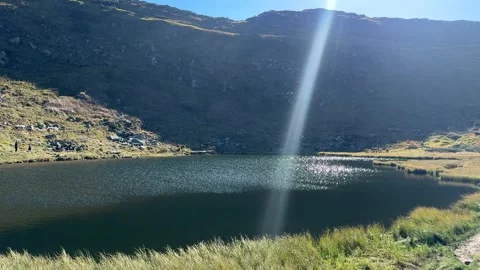 Mountain lake reflecting the sun's rays Stock Footage 318488933