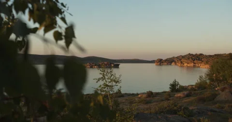 Mountain lake with a small island in the middle. Sunset lighting. Stock Footage 142127953