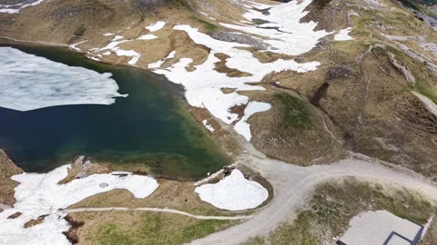 Mountain Lake Surrounded by Melting Snow in the Austrian Alps Stock Footage 336093340