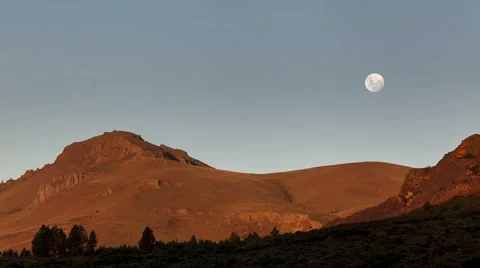 Mountain landscape and the full moon rising at sunset day to night time lapse Stock Footage 64835822