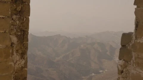 Mountain Landscape and Great Wall Watchtowers Framed by Ancient Stone Window Stock Footage 345680266