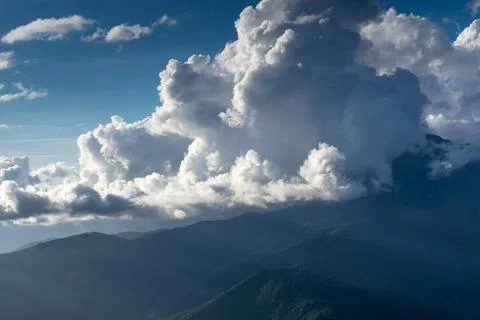 Mountain landscape on the background of the cloudy sky and sun rays Stock Photos