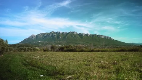 Mountain landscape with blue sky, clouds and green field time lapse in Cilento Video stock 255728192