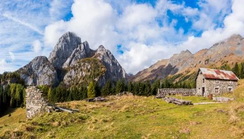 Mountain landscape with blue sky with clouds and ruins of an old farm. Stock Photos