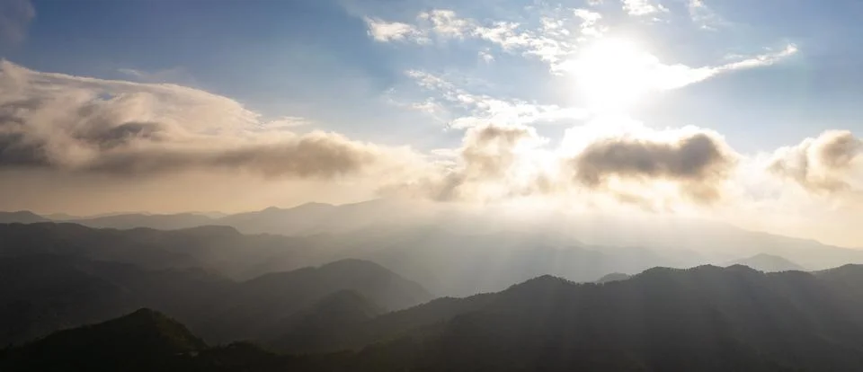 Mountain landscape with clouds and sun rays at sunset Stock Photos