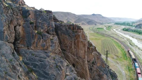 Mountain landscape in the distance a freight train is passing Stock Footage 161076157