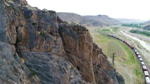 Mountain landscape in the distance a freight train is passing Stock Footage 161076287