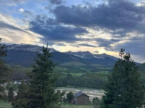 Mountain landscape at dusk, with dramatic clouds illuminated by the setting sun Stock Photos