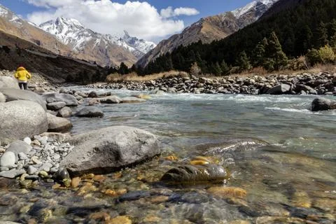 Mountain landscape featuring a clear river flowing through rocky terrain wi.. Stock Photos