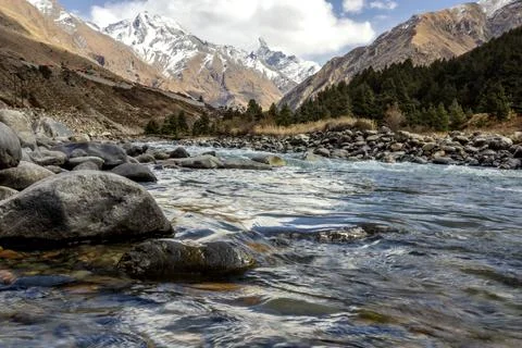 Mountain landscape featuring a clear river flowing through rocky terrain wi.. Stock Photos