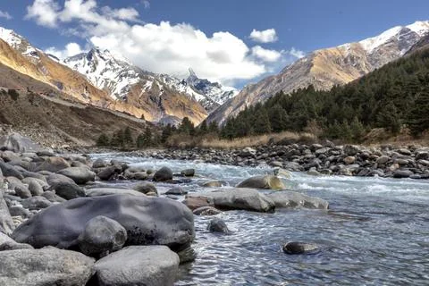 Mountain landscape featuring a clear river flowing through rocky terrain wi.. Stock Photos