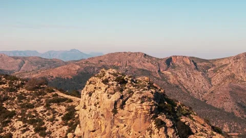 Mountain landscape featuring dramatic rock illuminated by golden sunlight, .. Stock Footage 303725915