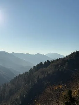Mountain landscape with forested slopes and a clear blue sky Stock Photos