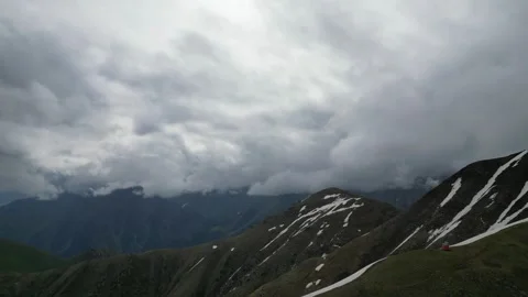 Mountain landscape with rolling clouds and snow-capped peaks in background Stock Footage 342312052