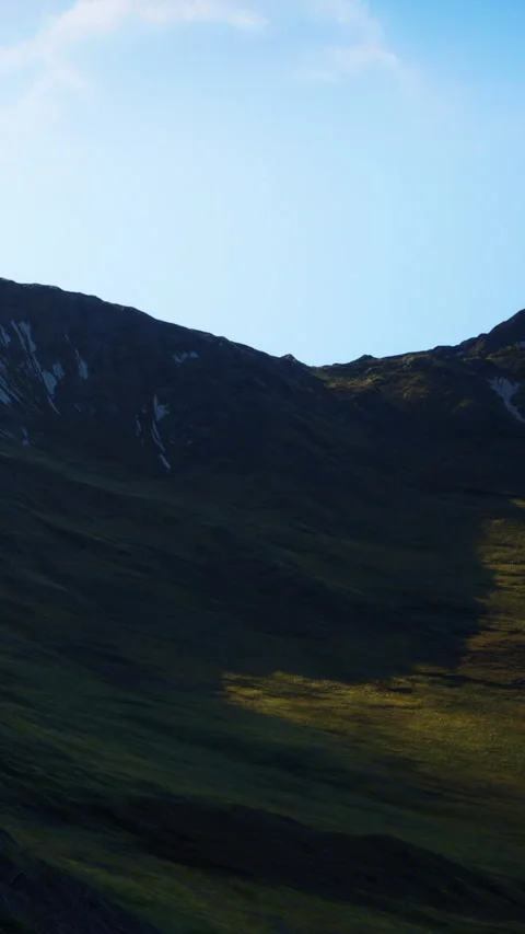 Mountain landscape shows shadows and sunlight on green slopes Stock Footage 341246891
