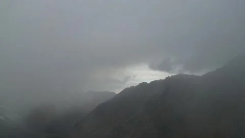Mountain landscape shrouded in mist, camera pans to reveal hidden peaks Video stock 320396800
