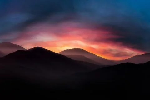 Mountain landscape at sunrise. Dramatic cloudy sunrise sky over mountain tops Stock Photos