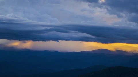 Mountain landscape at sunset with dark storm clouds and golden light. Stock Footage 287860292