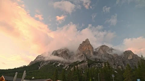 Mountain landscape at sunset with glowing clouds above rocky peaks 動画素材 319412425