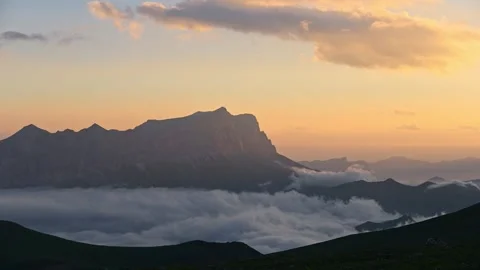 Mountain landscape transitions through clouds at sunset, serene natural beauty Stock Footage 341474933
