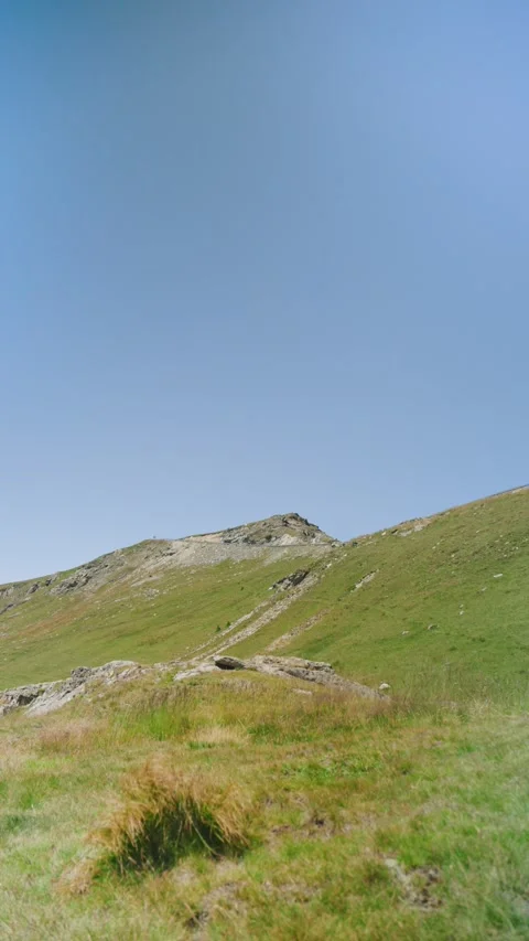 Mountain landscape under clear blue sky with grassy hills during daytime Stock Footage 343840503