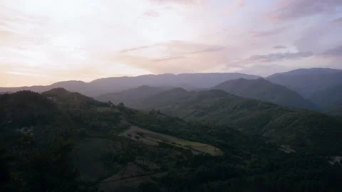 Mountain landscape view with soft rolling hills under a vibrant sunset sky Stock Footage 294947114