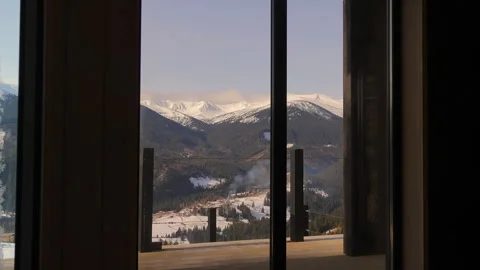Mountain landscape view through glass doors in winter cabin, snow-covered peaks Stock Footage 308496938