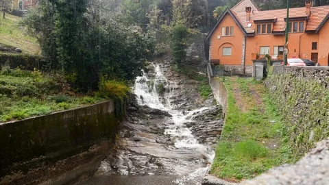 Mountain landscape with a waterfall next to a house on a rainy day Stock Footage 106720675