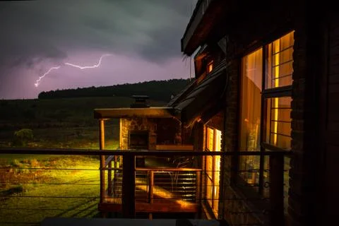 Mountain lodge with lightning in the background Stock Photos