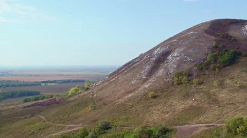 The mountain with a low slope is located in the valley. Agricultural fields and Stock Footage 154999966